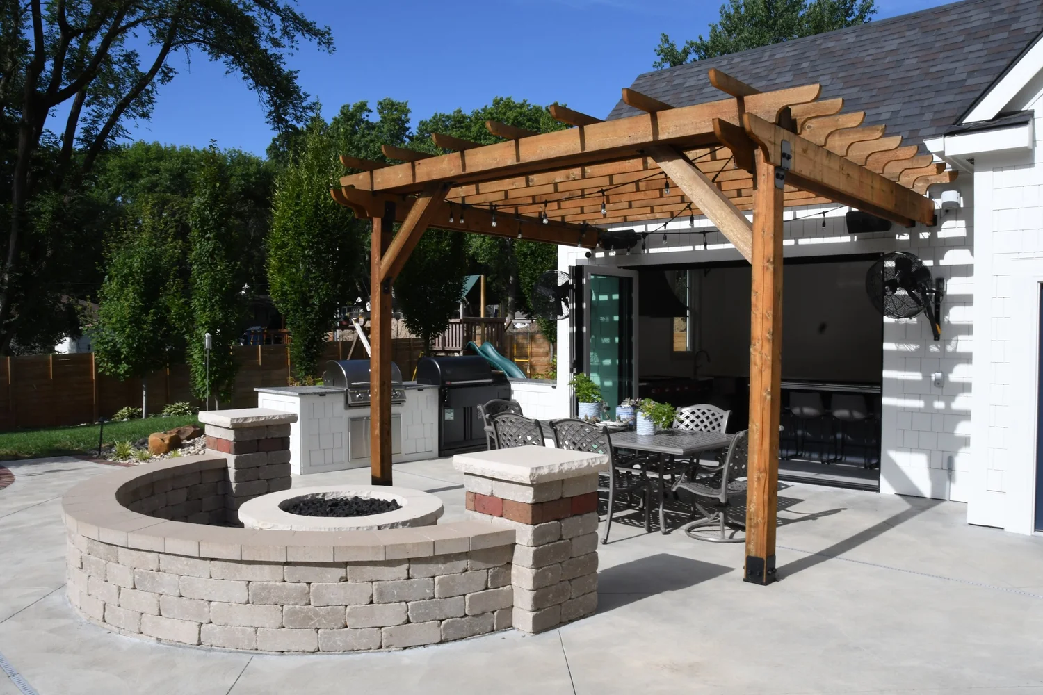 Custom pergola with fire pit and outdoor kitchen